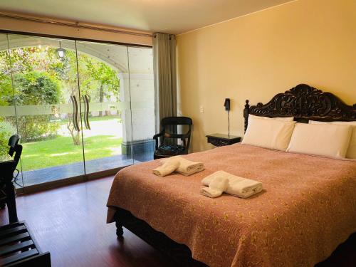 a bedroom with a large bed with two towels on it at Hotel Boutique Villa Elisa in Arequipa