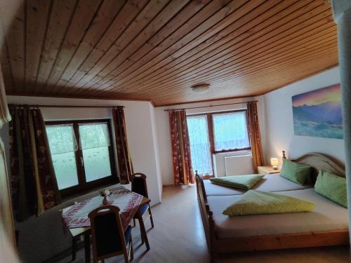 a bedroom with two beds and a wooden ceiling at Gasthof Grünsbach in Münster