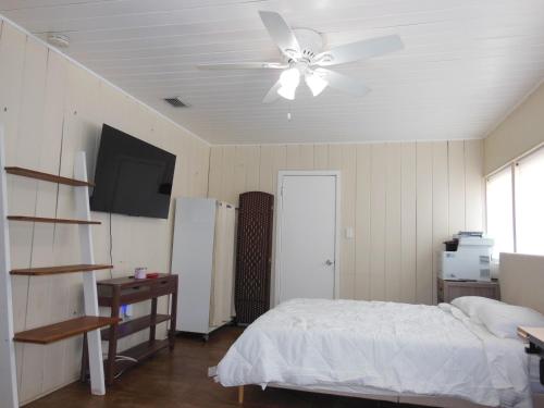 a bedroom with a bed and a ceiling fan at Indian Beach Cottage in Sarasota