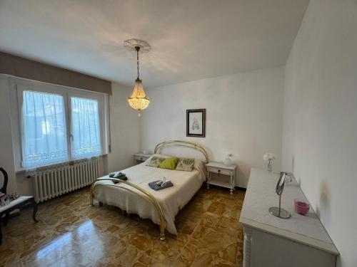 a bedroom with a bed and a chandelier at Casa Claudia in Riva di Solto