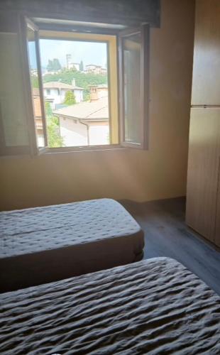 a bedroom with two beds and a window at Angela's House in Barga