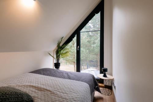 a bedroom with a bed and a large window at Villa Pino in Borsk