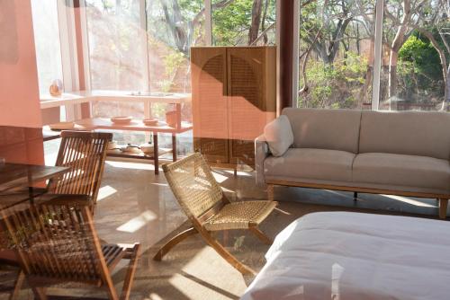 a living room with a couch and chairs and a table at Tropical Design Stay near Playa Avellanas with Rooftop Terraces in Santa Cruz