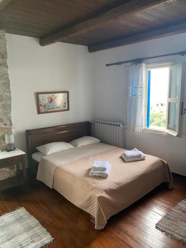 a bedroom with a bed with two towels on it at Aiolos in Skala