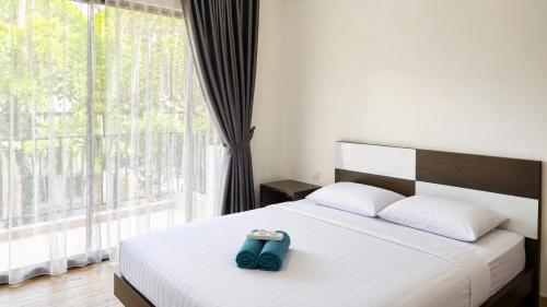 a bed with a blue bag sitting on top of it at SleepRest @ Nagoya Valley in Nagoya