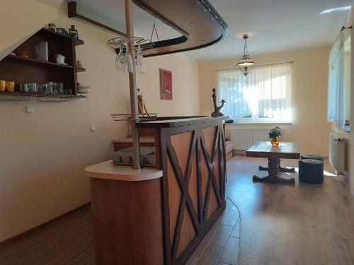a kitchen with a counter and a table in a room at W Sosnowym Lesie Pluski in Pluski