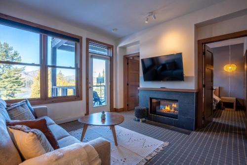 a living room with a couch and a fireplace at Suite with mountains view & Resort access in Lac-Superieur