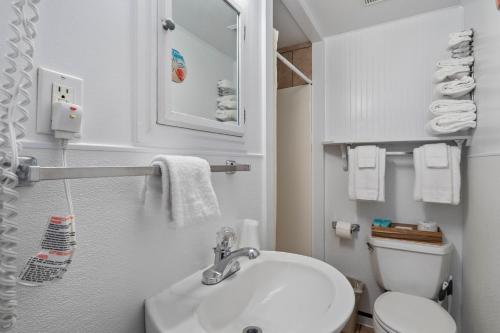 オーシャンサイドにあるOceanside Ocean Front Cabinsの白い洗面台とトイレのあるバスルーム