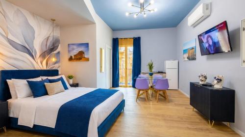 a bedroom with a king sized bed and a table at Almantra Rooms - Valle dei Templi e Mare in Favara