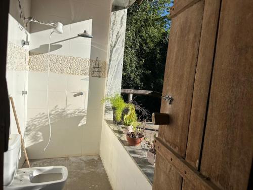 a bathroom with a toilet and a sink and a window at Chácara do Waltinho in Contagem