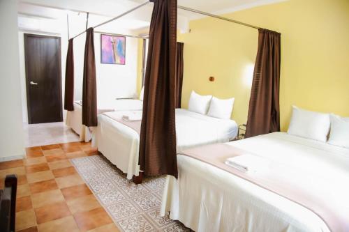 a hotel room with two beds and a mirror at Casa Janaab Palenque in Palenque