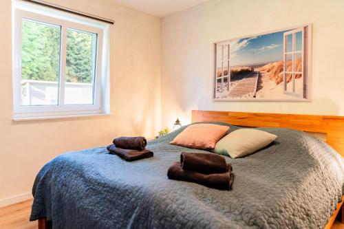 a bedroom with a bed with two pillows on it at Fördezauber - Ruhiges Ferienhaus mit eingezäuntem Garten und Kamin in Bönstrup