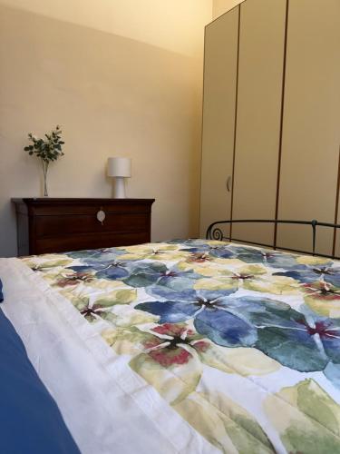 a bedroom with a bed with a flower quilt on it at The Fruit House in Cascina