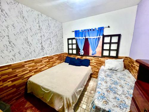 a bedroom with two beds and a window at Lar Doce Estadia in São Pedro da Aldeia