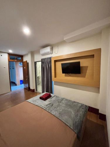 a bedroom with a bed and a tv on the wall at Sendja Residence in Semarang