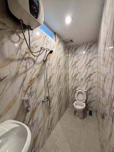 a bathroom with a white toilet and a sink at Sendja Residence in Semarang