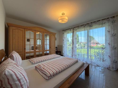 a bedroom with two beds and a large window at Casa Calvin in Unteruhldingen