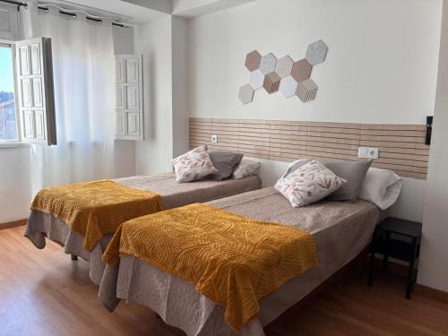 a bedroom with two beds with orange sheets at La casa de la abuela in Narón