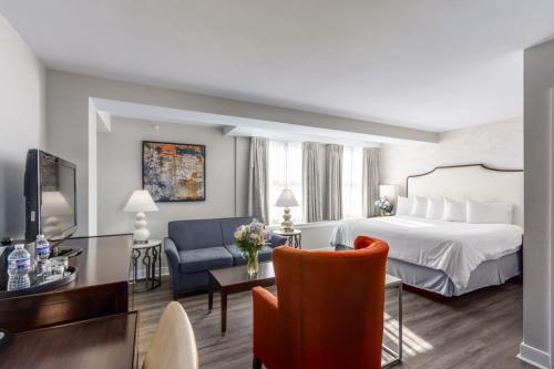 a hotel room with a bed and a living room at The Georgetown Inn in Washington, D.C.