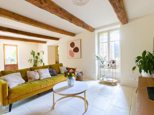 a living room with a yellow couch and a table at Mas provençal - Idéal familles & amis - Piscine privée - 3 suites - Avignon & Châteauneuf-du-Pape - Parking privé gratuit in Bédarrides
