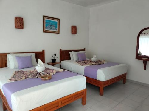 two beds sitting next to each other in a room at Hotel Quinta Paraiso in Cocoyoc