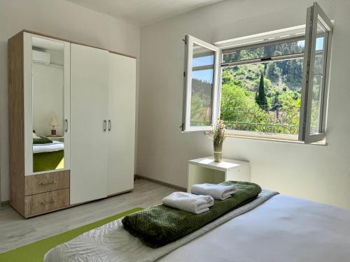 a bedroom with a bed with two towels on it at Green House Cuprija in Stolac