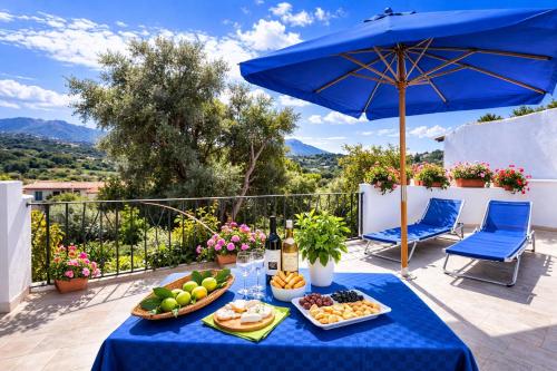 a blue table with food and wine on a balcony at La Vignaredda - Residenza di Charme in Aggius