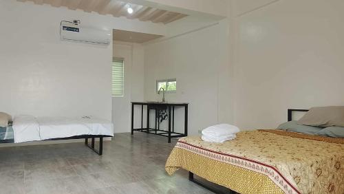 a white room with two beds and a table at Hidalgo Lodge in Santa Ana