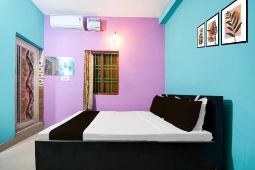 a bedroom with a bed with purple and blue walls at Hotel O The Shivansh Inn in Chandanpur