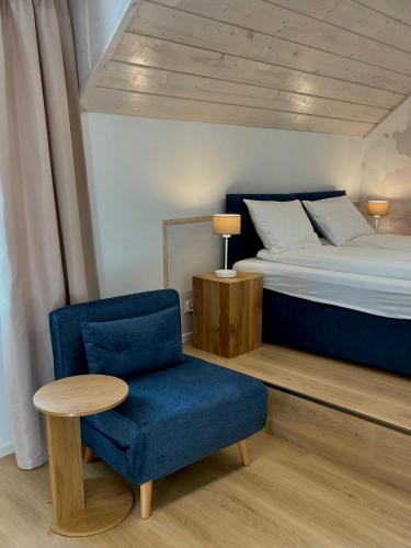 a bedroom with a bed and a chair and a table at Dom Gościnny Zakole in Buda Ruska