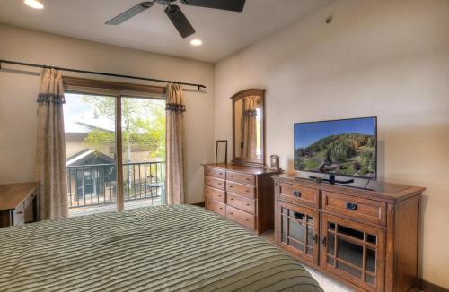 a bedroom with a bed and a dresser with a television at Elkpoint Unit 11 in Durango Mountain Resort