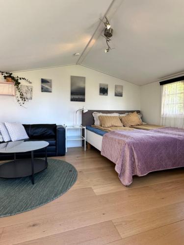 a bedroom with a bed and a couch at Mysig stuga i lugnt villaområde med eget badrum och kök i huvudbyggnadens källare in Kalmar