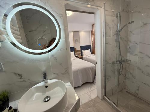 a bathroom with a sink and a shower and a mirror at Assamaris in Asprovalta