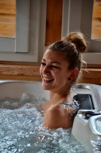 a young woman is sitting in a bathtub at Chambre d hotes Spa montagne in Laruns