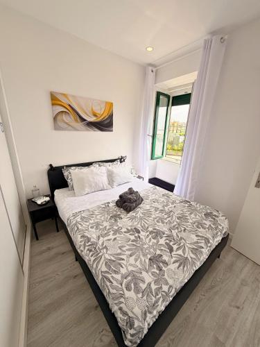 a bedroom with a bed with a black and white comforter at Naval - Marina View Apartments in Vila do Conde