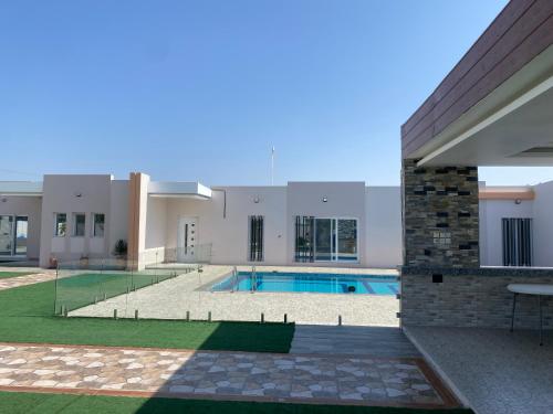 a villa with a swimming pool and a building at Rovana Chalet in Barka