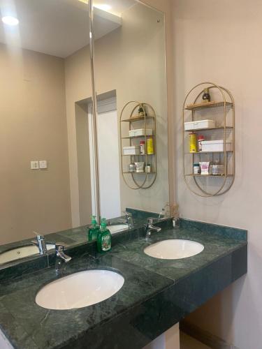 a bathroom with two sinks and a large mirror at Rovana Chalet in Barka