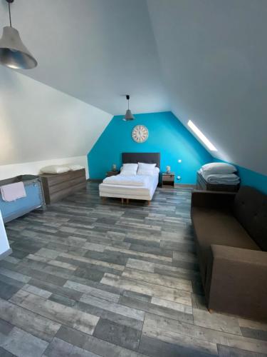a bedroom with a bed and a blue wall at Maison typique auvergnate in Saint-Jacques-des-Blats
