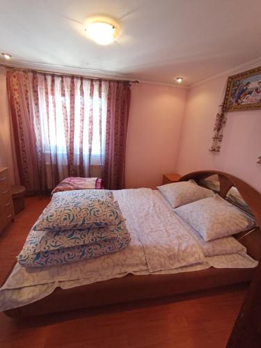 a bedroom with a large bed and a window at Котедж - Prestige in Vorokhta