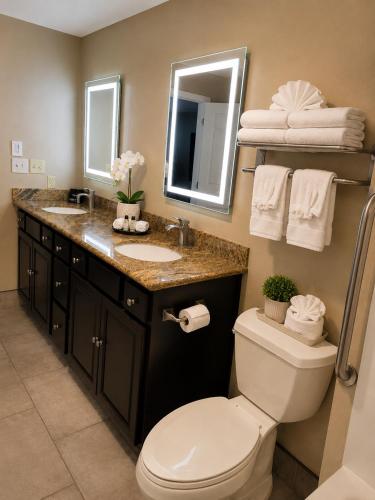 a bathroom with a toilet and a sink and a mirror at Best Western John Day Inn in John Day