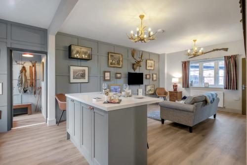 a living room with a kitchen and a living room with a couch at Pools Cottages - Warwick Luxury Countryside Near NEC in Kenilworth