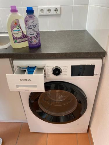 a white washing machine under a counter in a kitchen at Apartment am Paradiespark in Jena