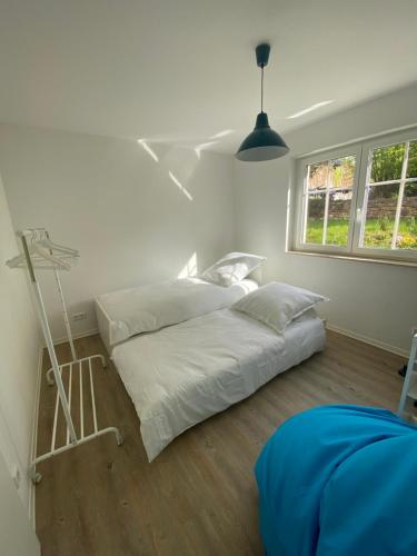two beds in a room with white walls and wood floors at Apartment am Paradiespark in Jena
