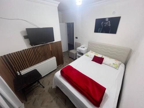 a small bedroom with a bed and a television at AirPort geust house in Arnavutköy