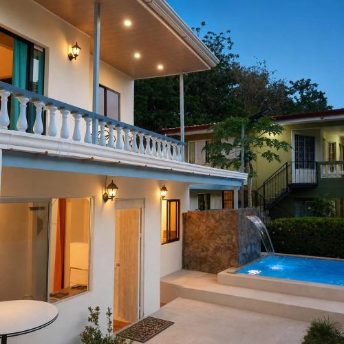 a villa with a swimming pool and a house at Hospedaje de la playa in Sámara