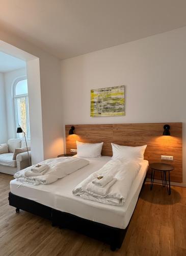 a bedroom with a large bed with white sheets at Strandresidenz Villa Verdi in Kühlungsborn