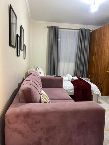 a living room with a couch and a bed at Ruaka Karington Studio in Ruaka