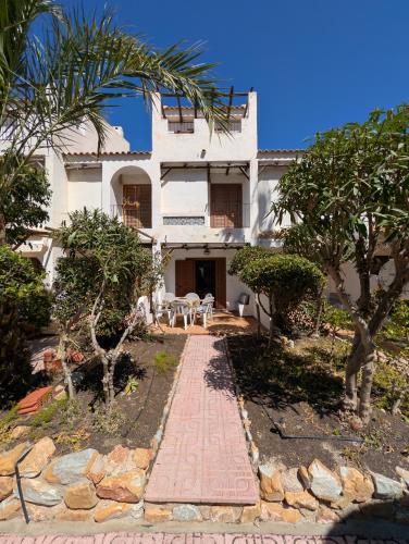 a large white house with a brick walkway at Jardín secreto del Mar Menor, La Manga in San Javier
