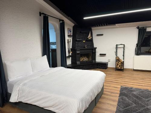a bedroom with a large bed and a fireplace at MarinaBlueGarden34 in Karaburun