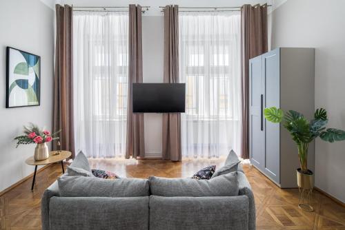 a living room with a couch and a flat screen tv at Cracow Main Square Apartments in Krakow
